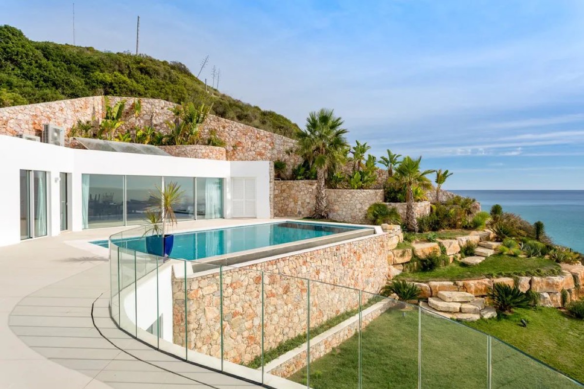 Modern luxury villa in the Algarve, Portugal, with infinity pool and contemporary stone architecture overlooking the Atlantic Ocean